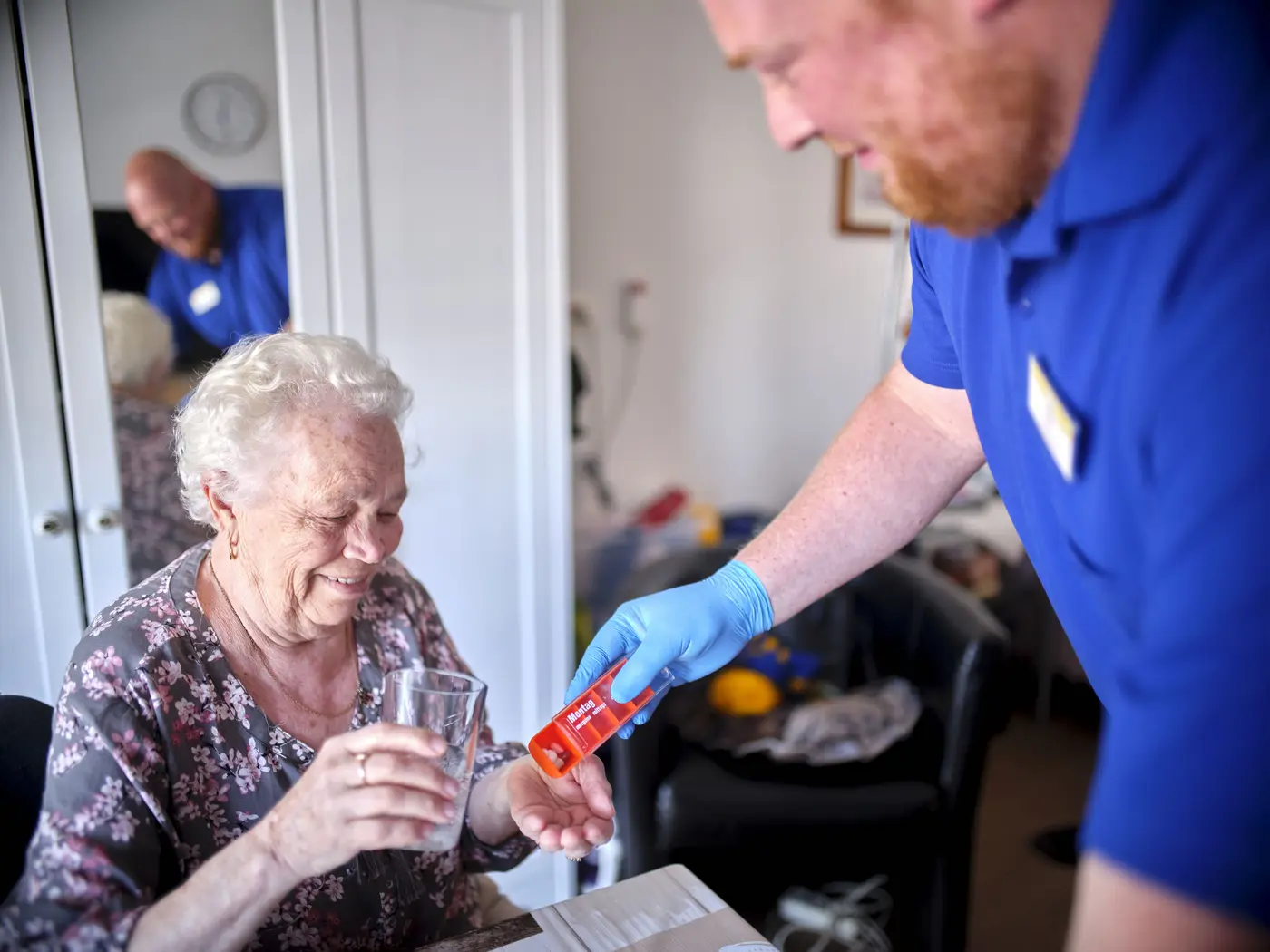 Eine Pflegekraft versorgt eine Seniorin.