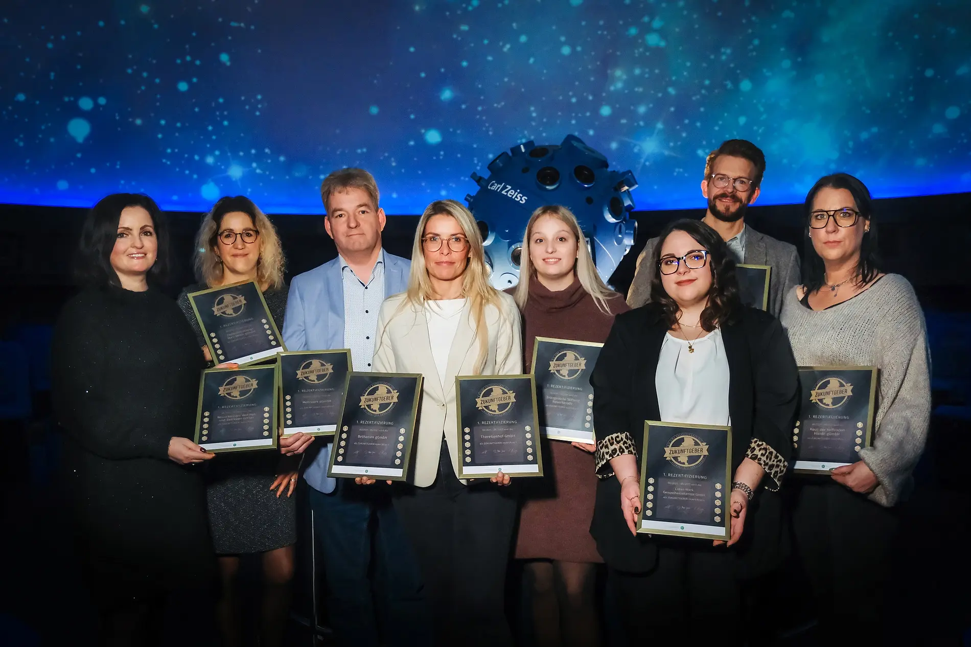 Die Ausgezeichneten präsentieren ihre Zertifikate.