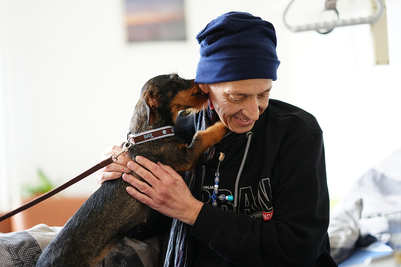Therapiehund Toni spielt mit einem Patienten