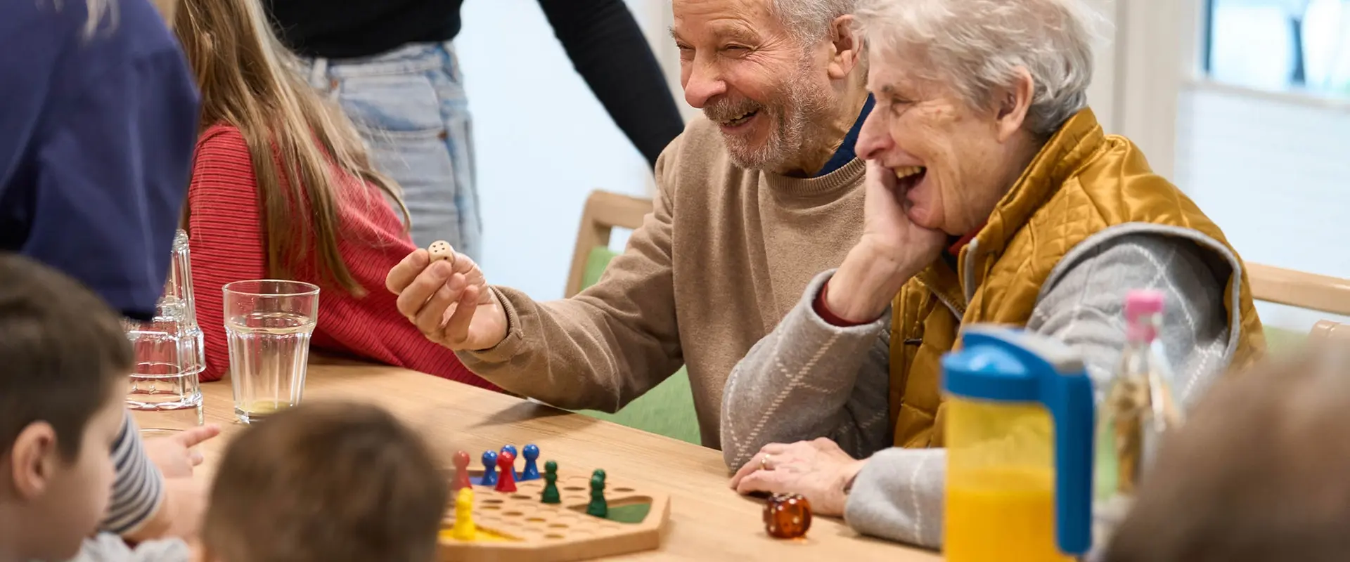 Senioren beim Brettspiel mit Kindern