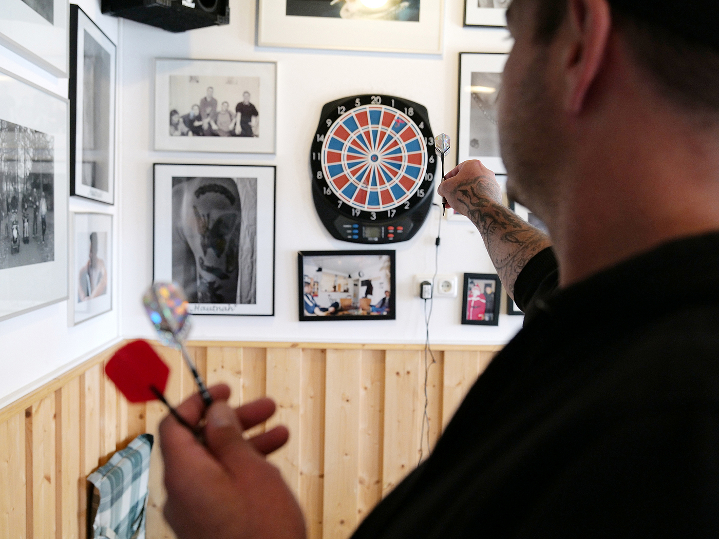 Mann zielt auf Dartscheibe