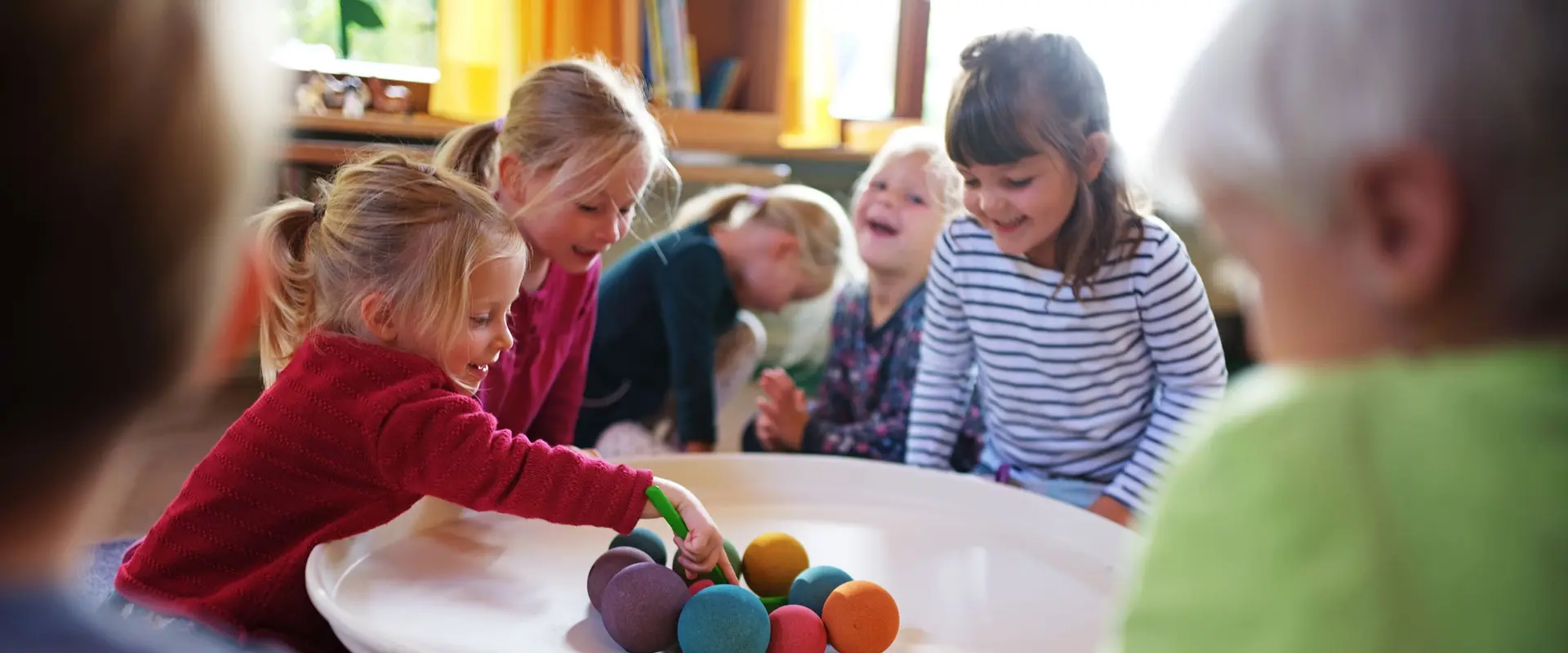 Kinder spielen in der Kita mit Bällen