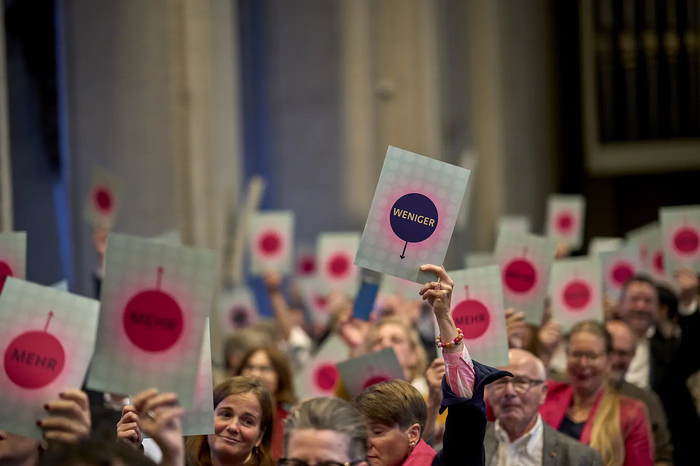 Menschen halten beim Stiftungsempfang der Evangelischen Stiftung Neuerkerode Schilder hoch.