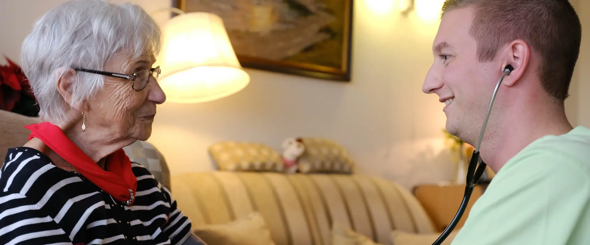 Pfleger und Seniorin bei Blutdruckmessen