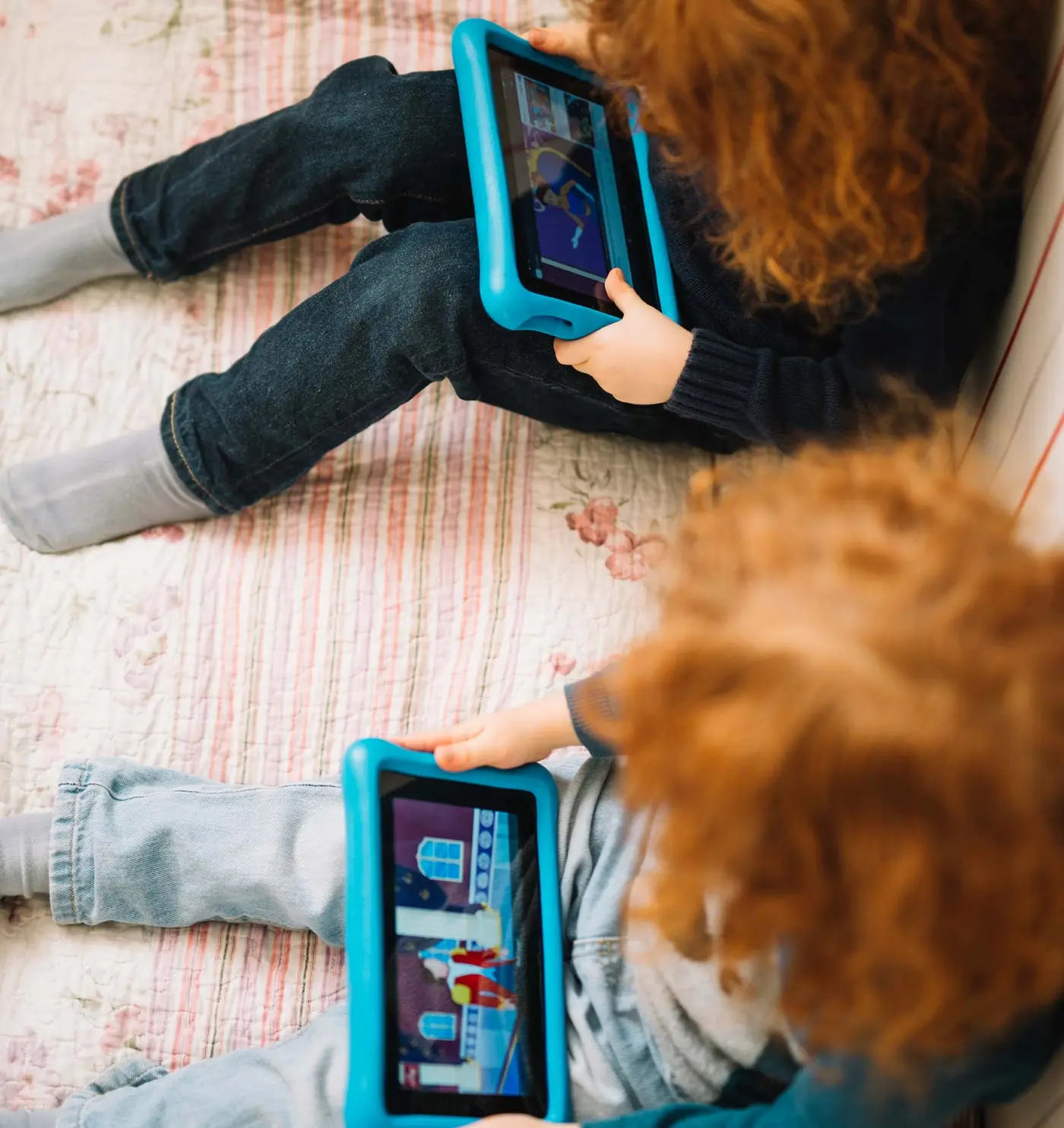 Kinder auf einem Sofa mit einem Tablet in der Hand