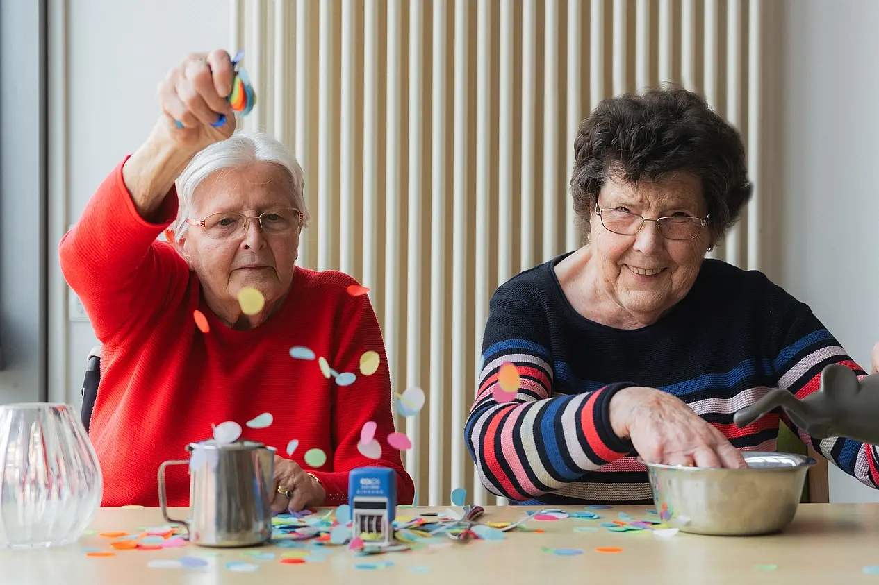 zwei Frauen aus dem Seniorenheim Bethanien werfen Konfetti