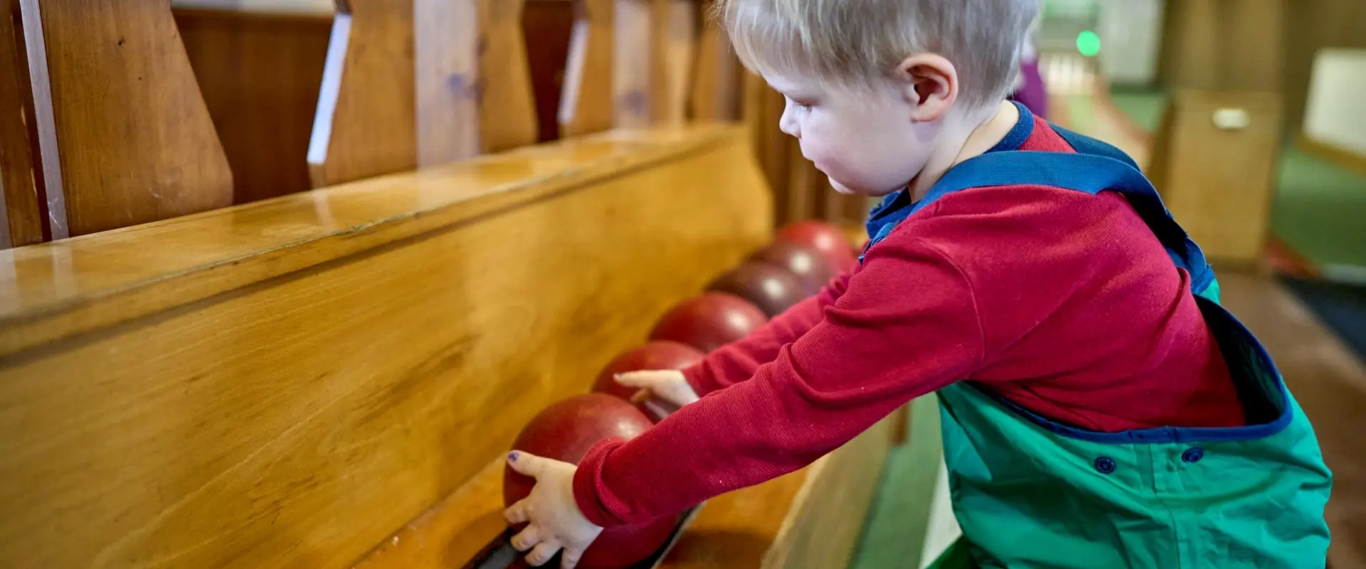 Kind greift nach Kegelkugel