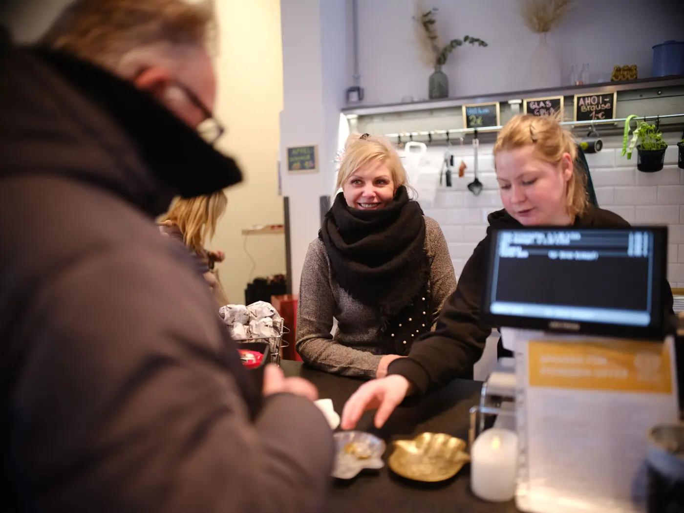 Das Kiosk-Team an der Kasse mit einem Kunden