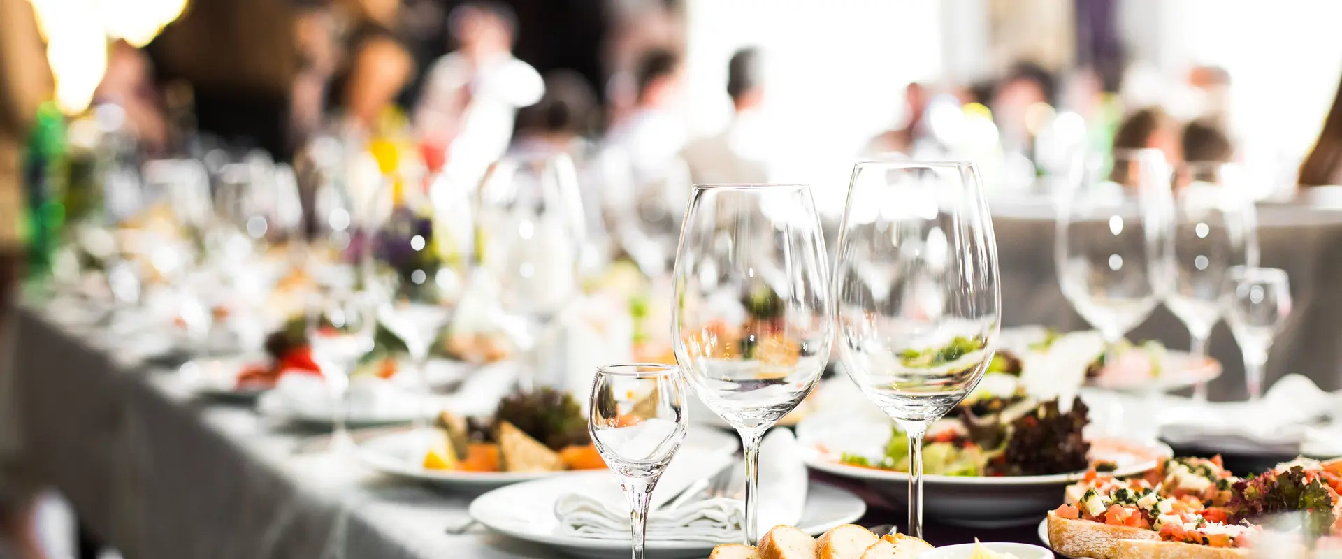 Feierlich gedeckter Tisch mit Weingläsern, Catering und weißer Tischdecke