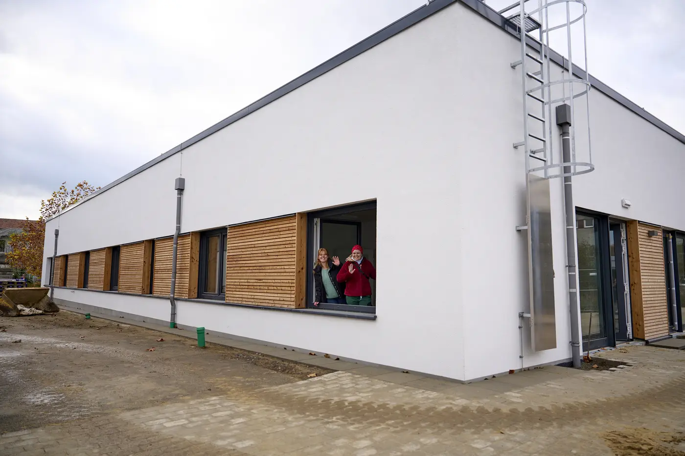 Außen Ansicht der Neubaus in Neuerkerode. Weißes Putz, dunkle Fenster, Holz-Elemente.