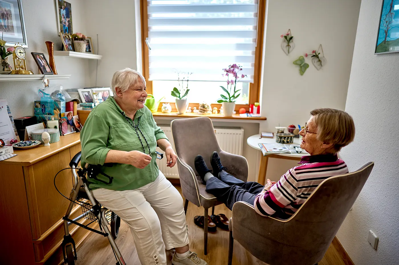 Zwei Frauen unterhalten sich in einem Seniorenzimmer.