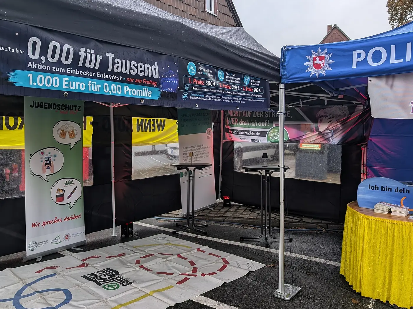 Infostand von Außen mit Bannern und Plakaten des Lukas Werks, der Polizei und dem Aktionsnamen