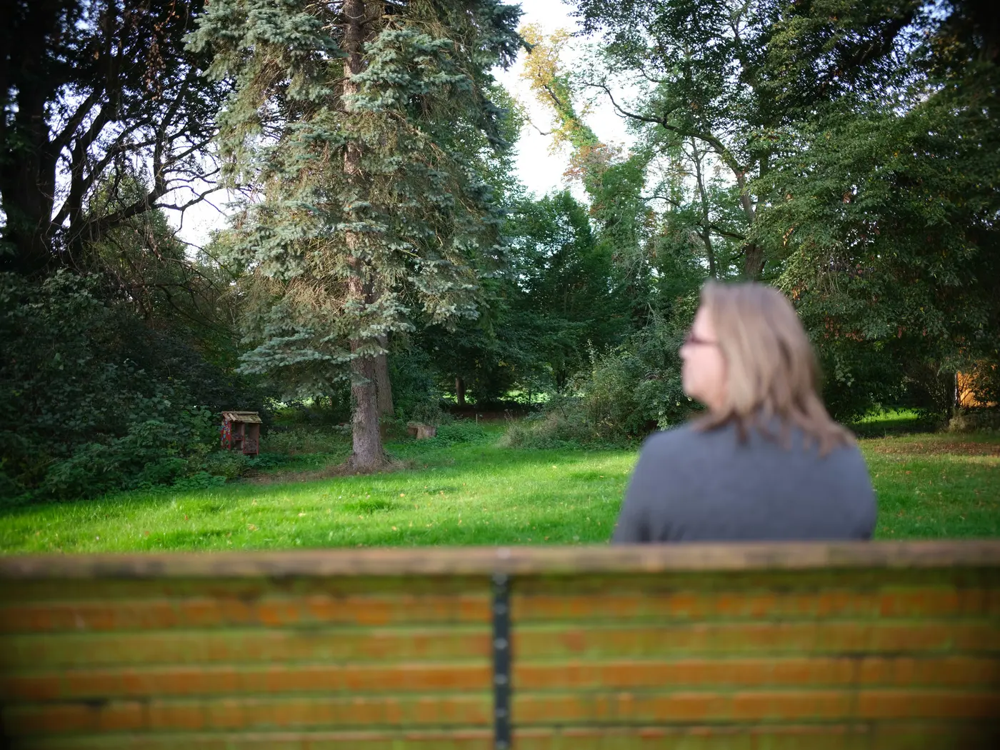 Frau sitzt auf Bank in Park