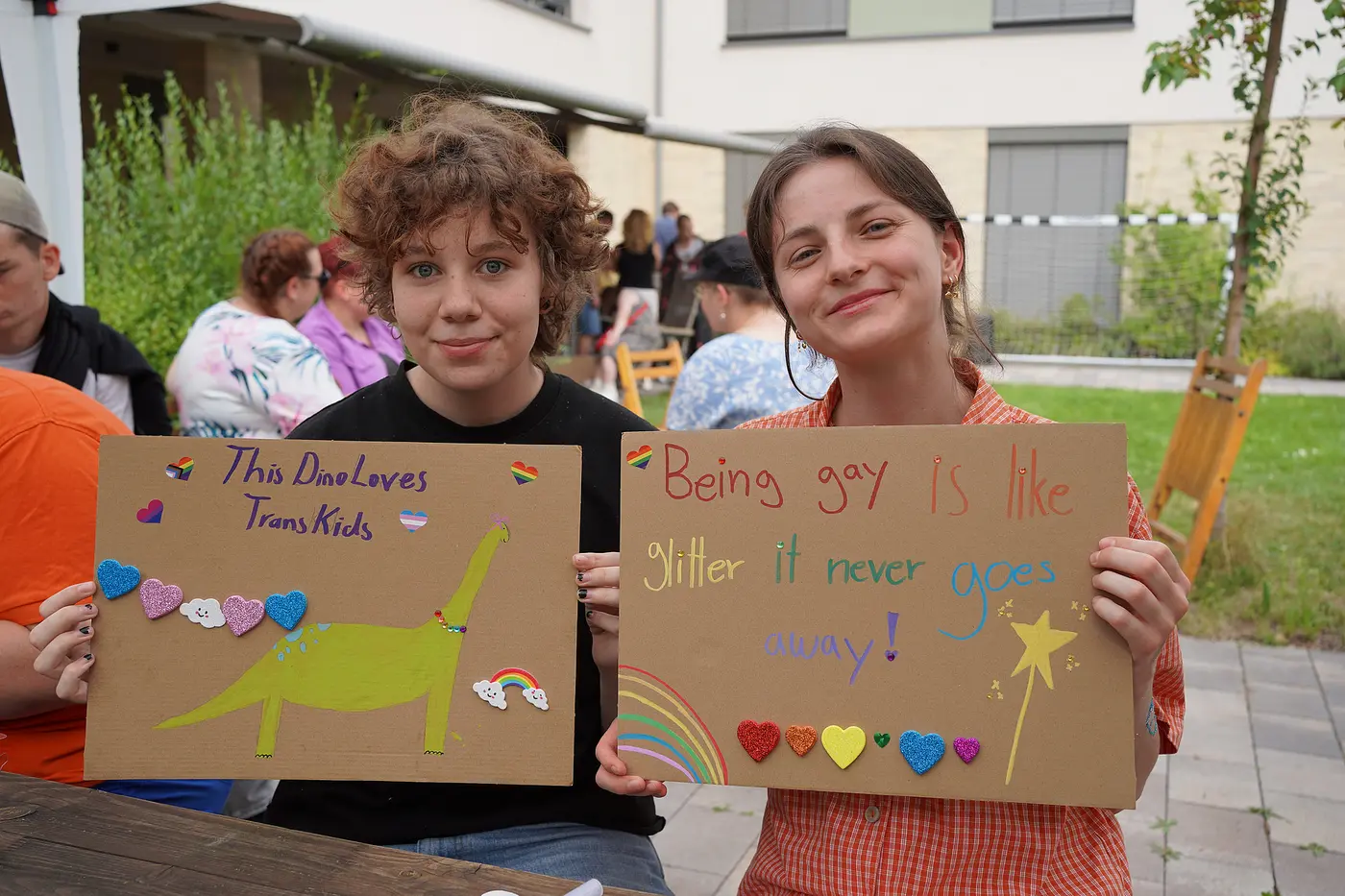 Das Bild zeigt die Menschen mit ihren Plakaten, die sie für den CSD Braunschweig gestaltet haben.