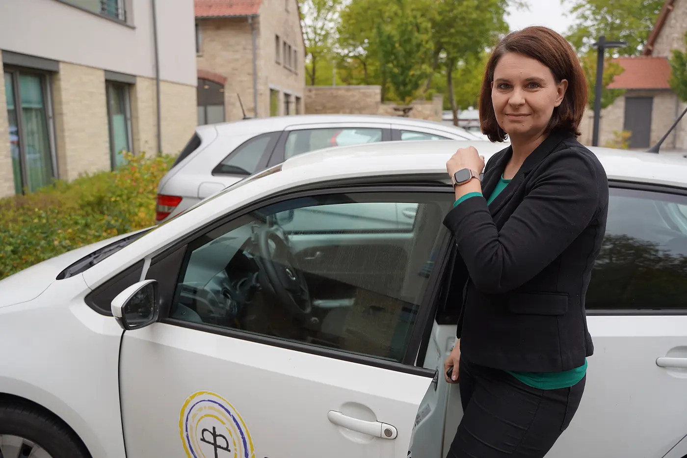 Nancy Neumann steht neben einem Auto der Diakoniestationen Harz-Heide.