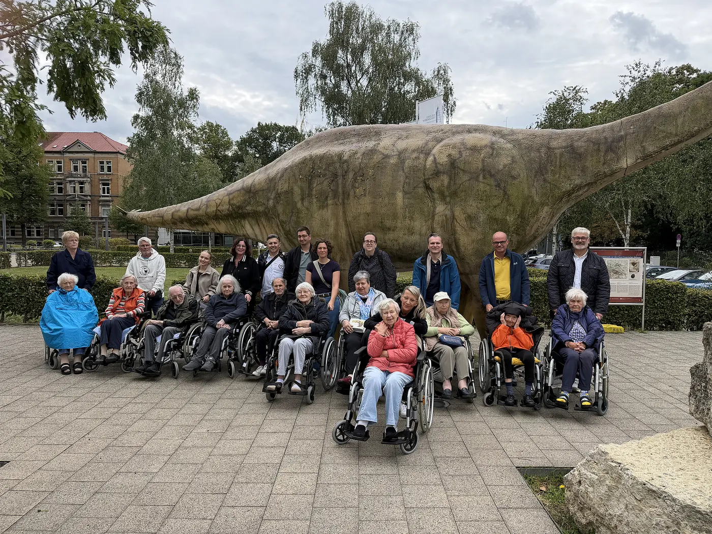 Die Gruppe steht vor einem der Dinosaurierfiguren vor dem Naturhistorischen Museum in Braunschweig.