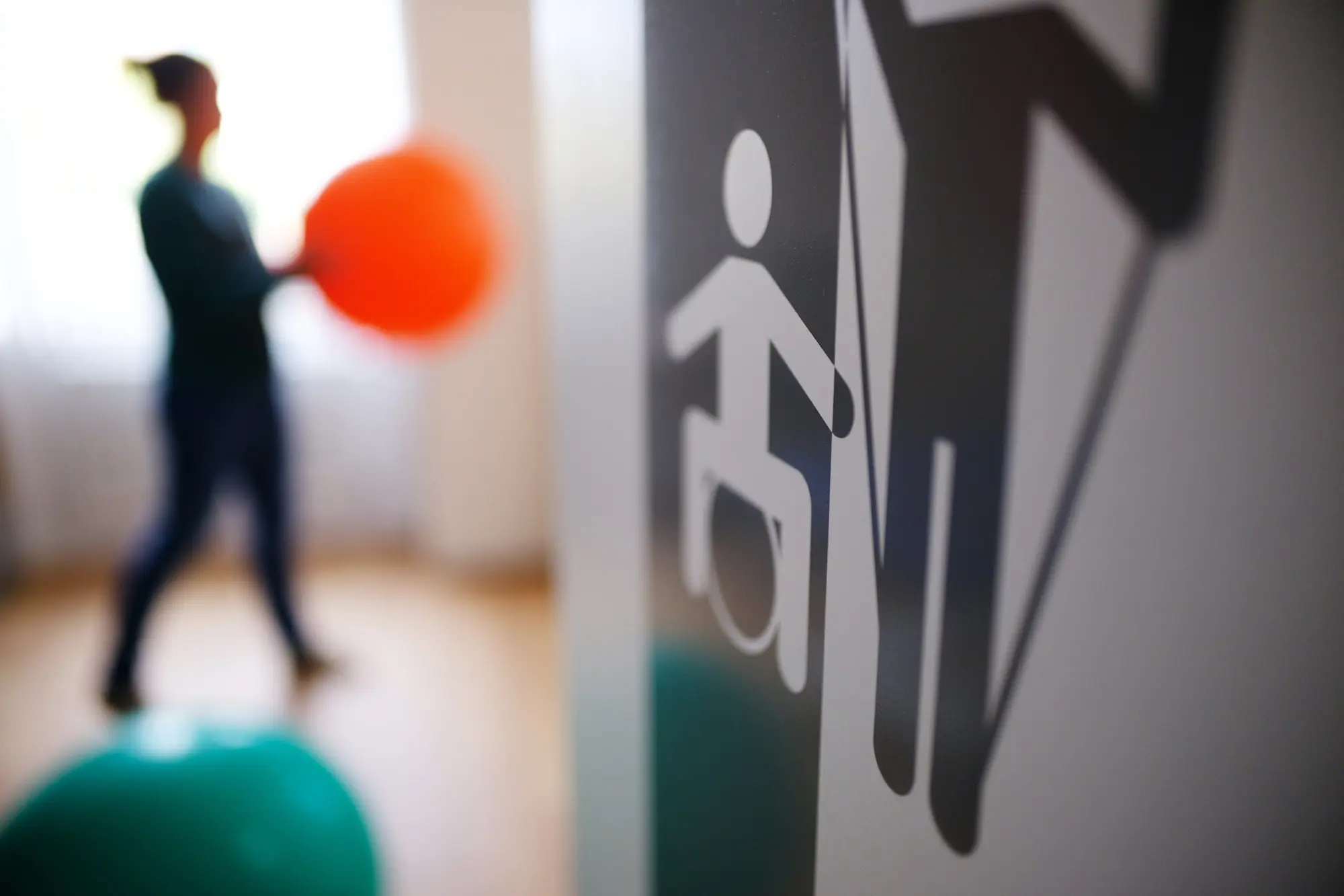 MZEB in Braunschweig. Blick in die Physiotherapie eine Frau hält einen großen orangenen Ball