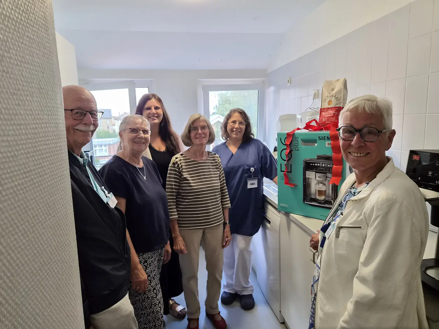 Mitglieder der Diakonischen Gemeinschaft übergeben Kaffeevollautomaten an Sabine Kohl von der Palliativstation.
