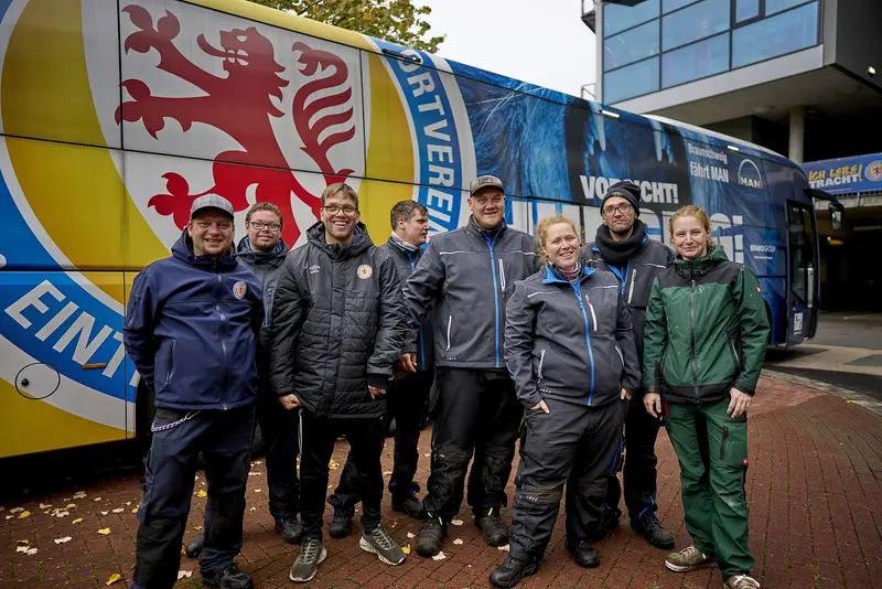 Team der Greenkeeper steht vor dem Bus von Eintracht Braunschweig 