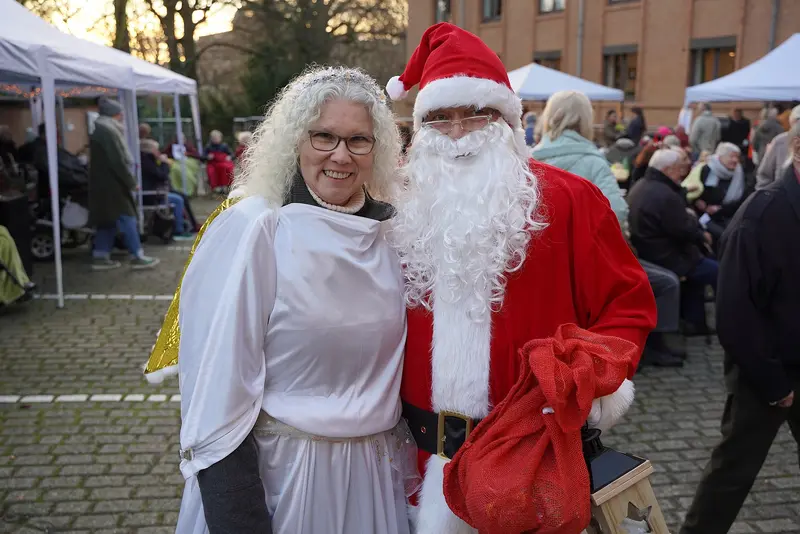 Ein Weihnachtsmann und ein Engel auf dem Weihnachtsmarkt rund um den Max-Beckmann-Platz.