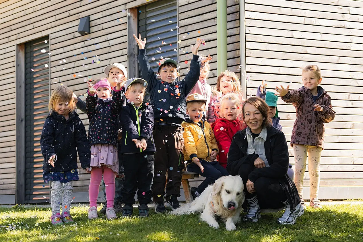 Kita Hund Kono mit den Kindern, die Konfetti werfen