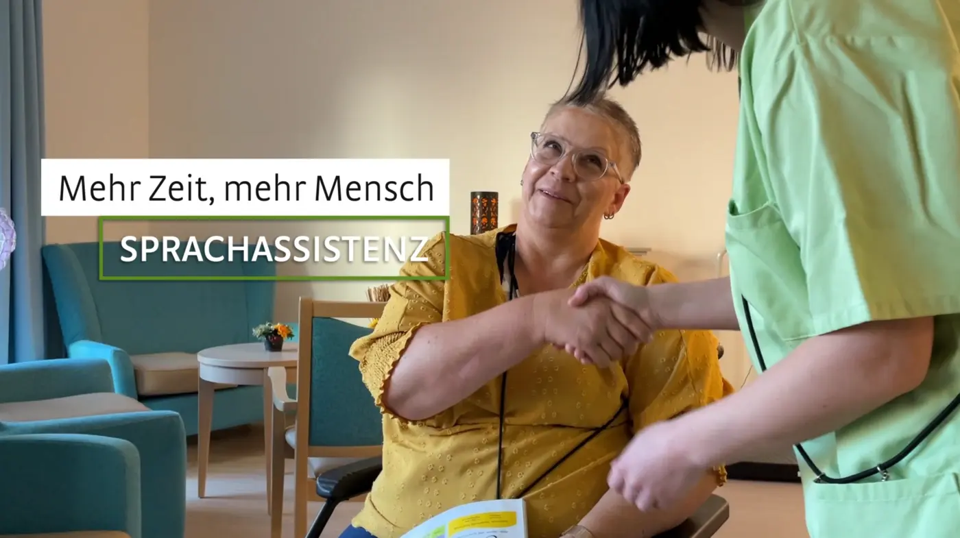 Eine Pflegekraft wendet sich einer Seniorin zu.