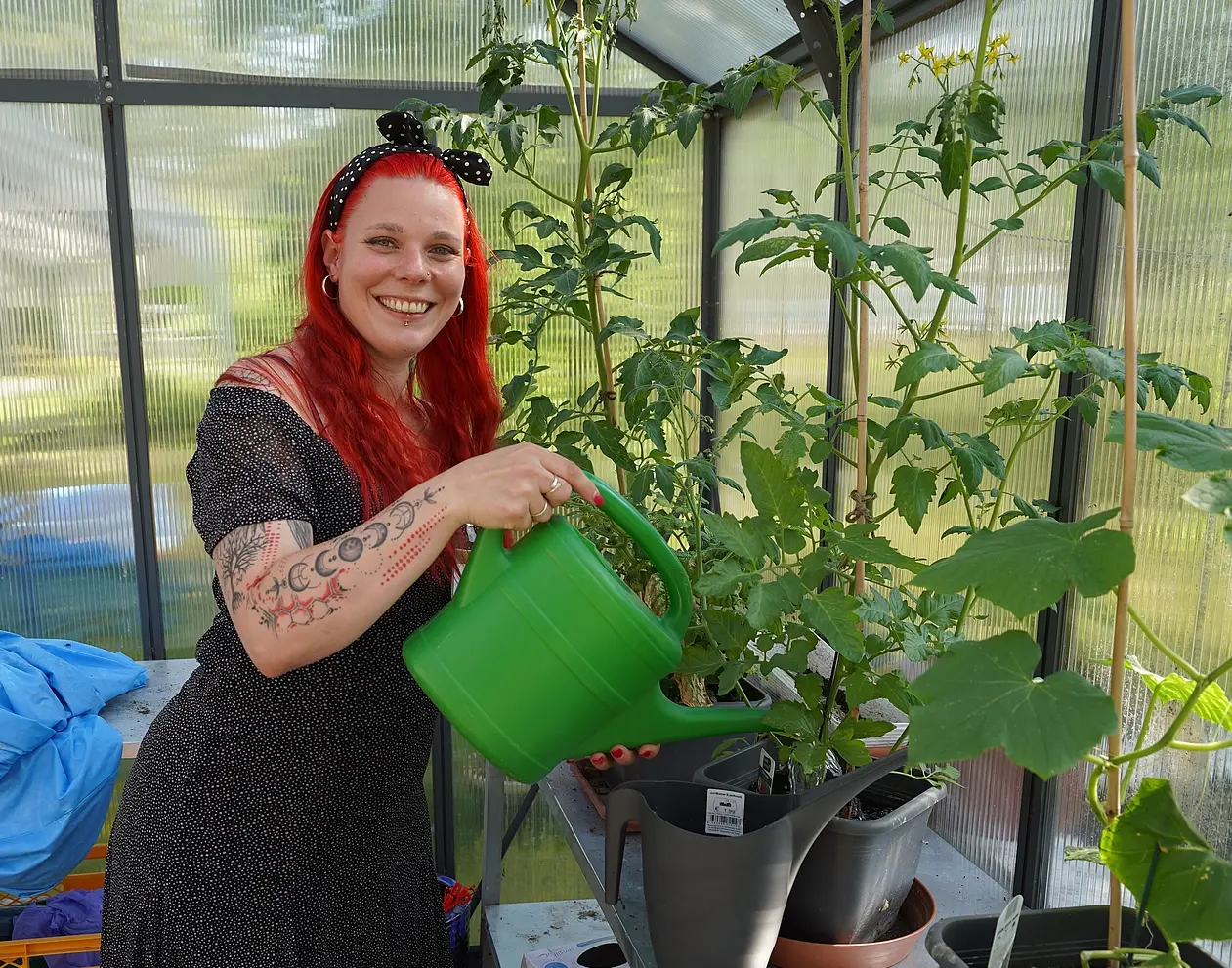 Sarah Zimmer gießt Pflanzen im Gewächshaus des Theresienhofs.