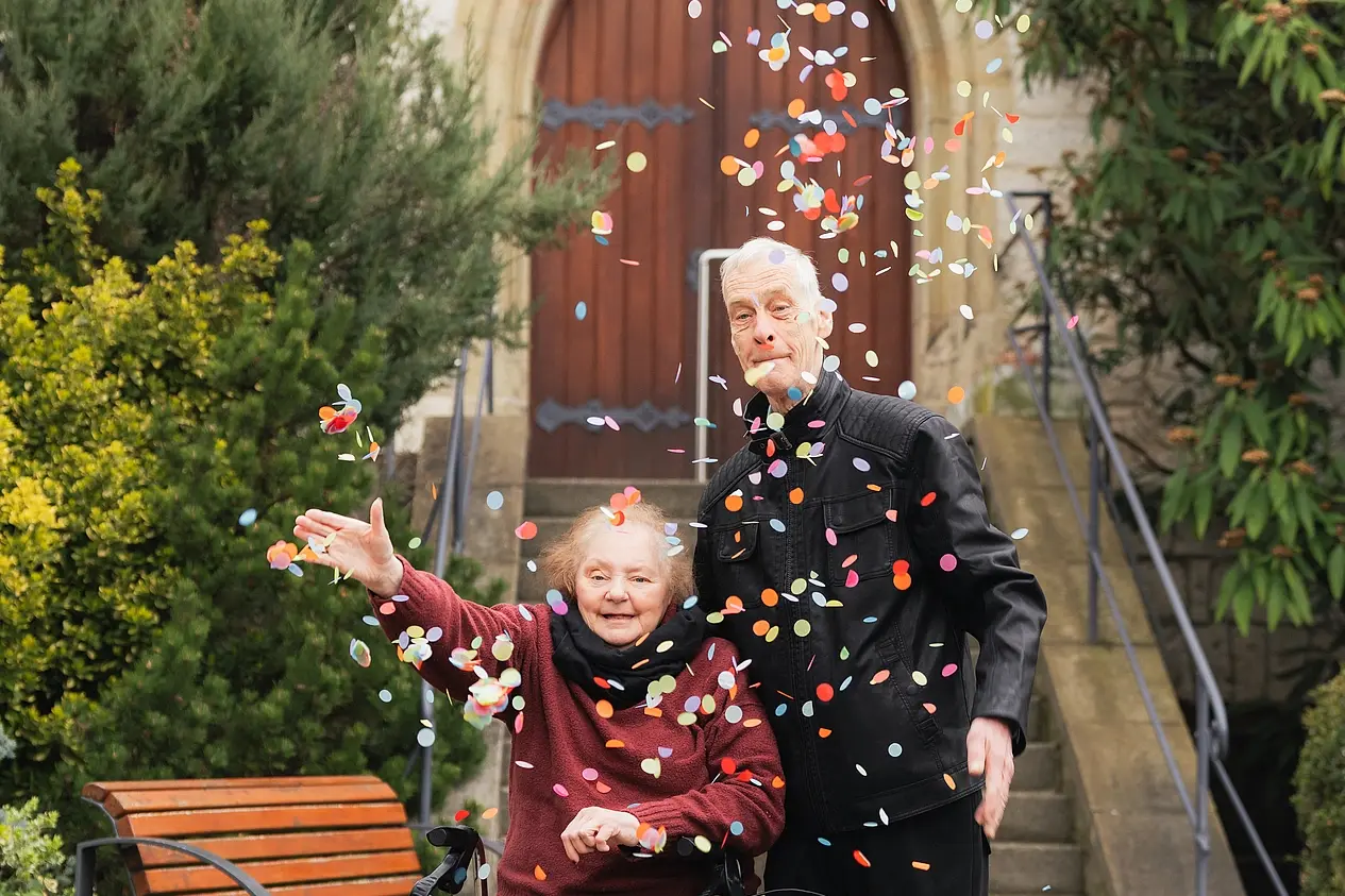 Alfred und Monika werfen Konfetti von der Kirche in Neuerkerode