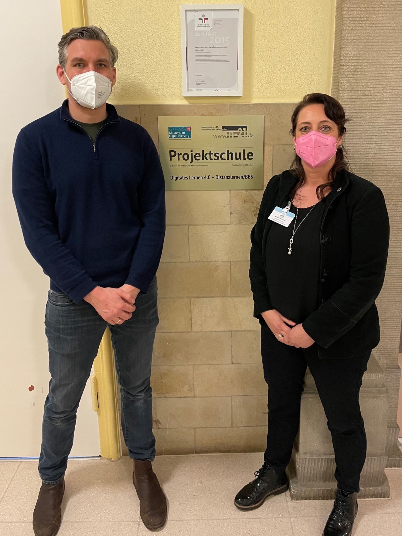 Monique Körber,-Bohm, lehrkraft Bildungszentrum Marienstift und Michael-Peter Jordan, Mitarbeiter der Projektgruppe, vor der Plakette "Digitales lernen 4.0 – Distanzlernen“